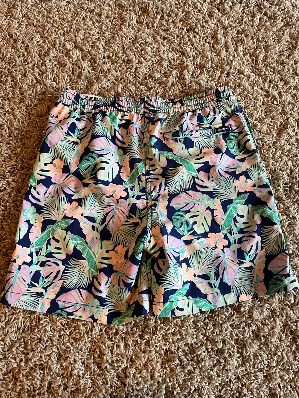 Chubbies youth medium swim trunks with a navy blue base floral print. - Picture 2 of 3